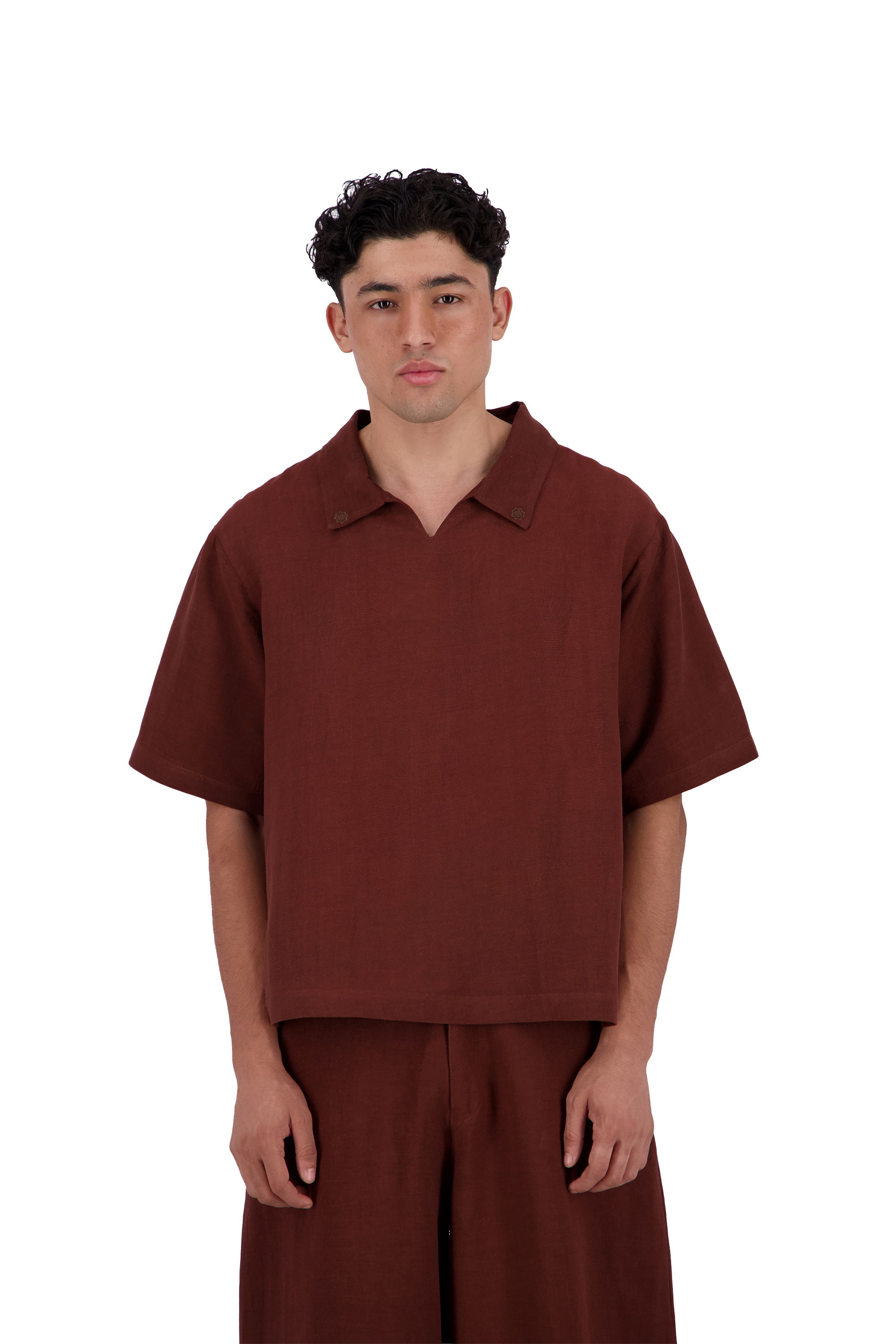 A man wearing a short-sleeve collared polo shirt and matching wide-leg trousers in a solid dark reddish-brown color, photographed against a plain white background. #Burnt_Clove