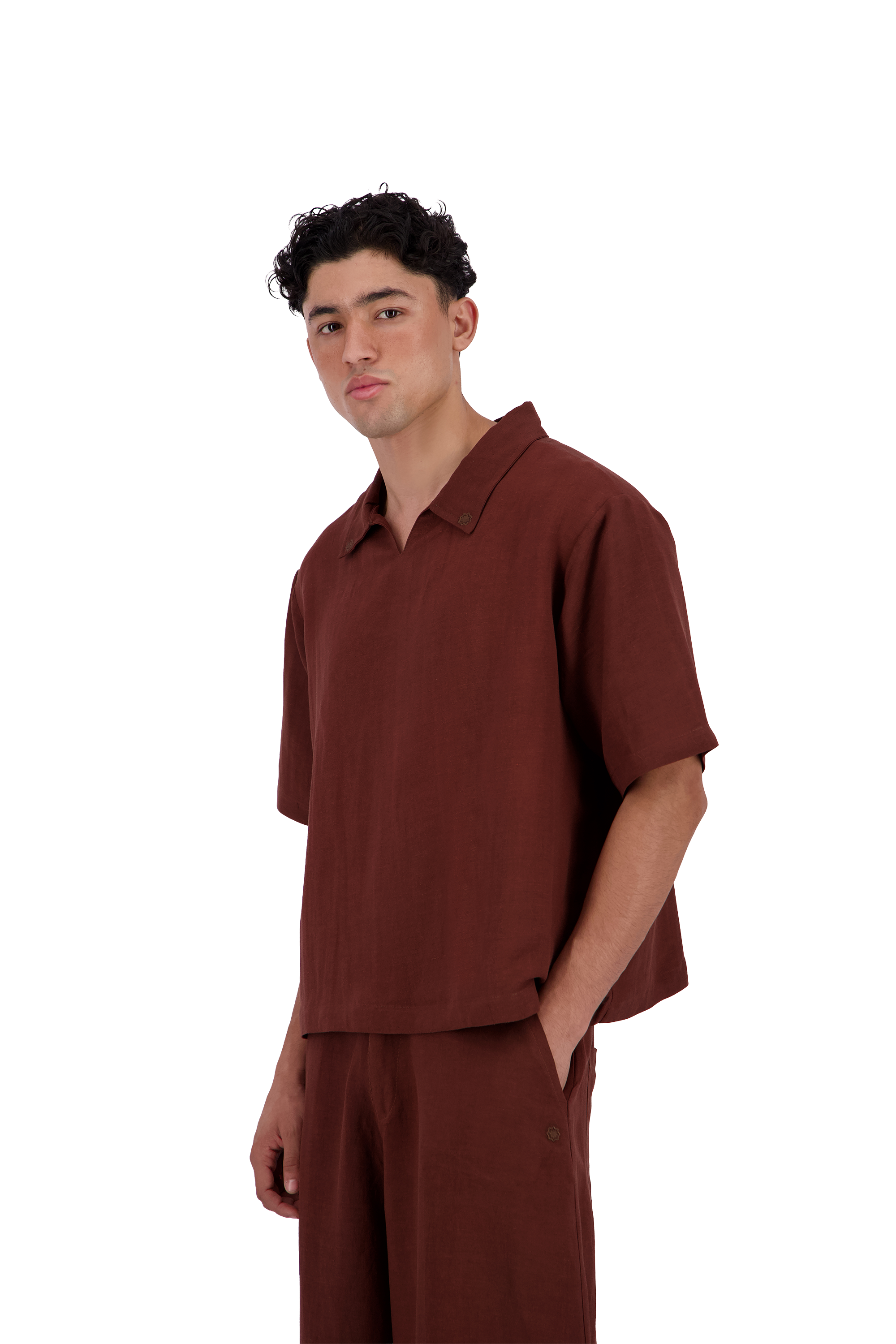 A man wearing a matching rust-brown short-sleeve polo shirt and trousers, standing against a solid white background. #Burnt_Clove