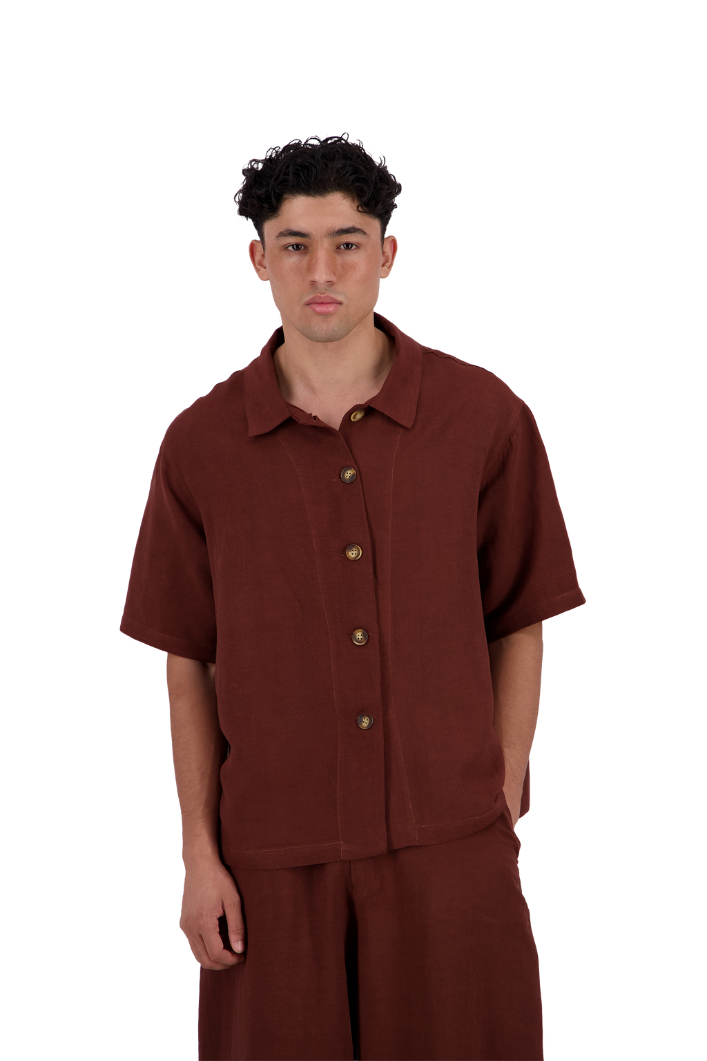 A man wearing a rust-brown short-sleeve button-up shirt and matching pants, standing against a plain white background. #Burnt_Clove