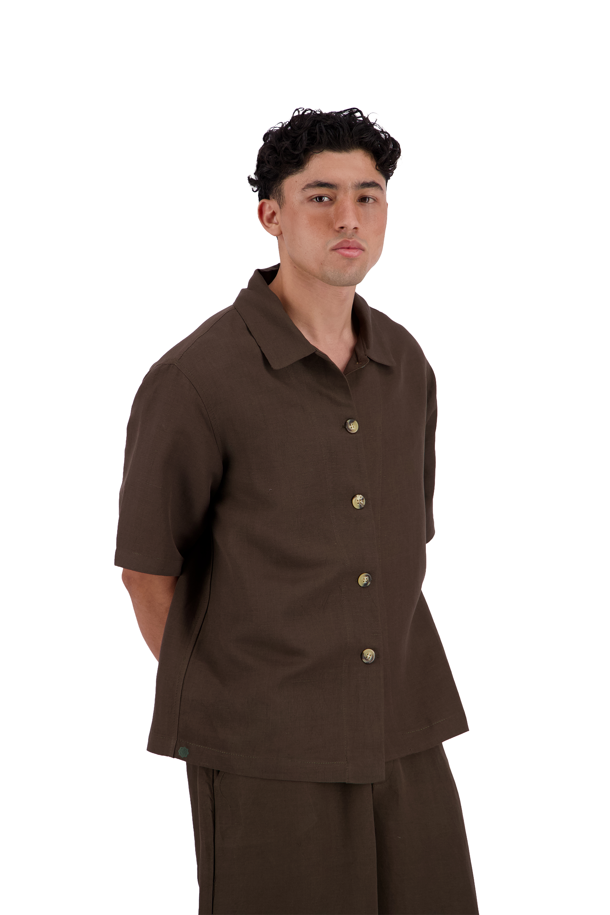 A man wearing a dark brown short-sleeve button-up shirt and matching dark brown pants, photographed against a solid white background. #Cumin_Leaf