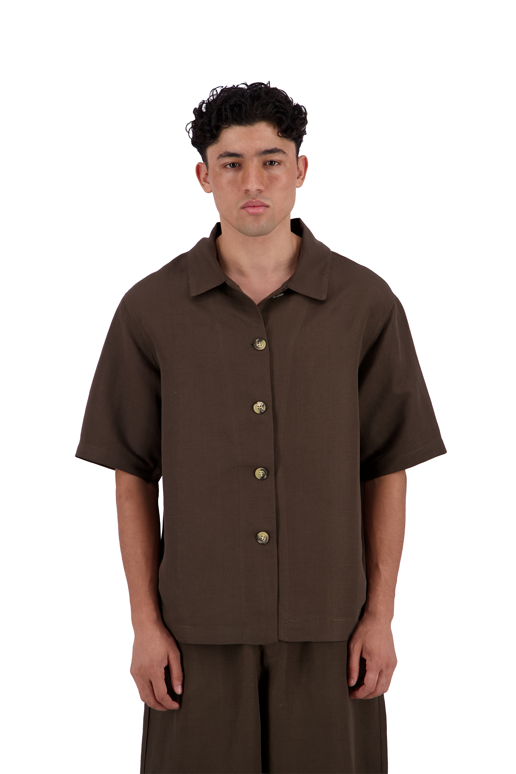 A man wearing a dark brown short-sleeve button-up shirt and matching brown pants, standing against a solid white background. #Cumin_Leaf