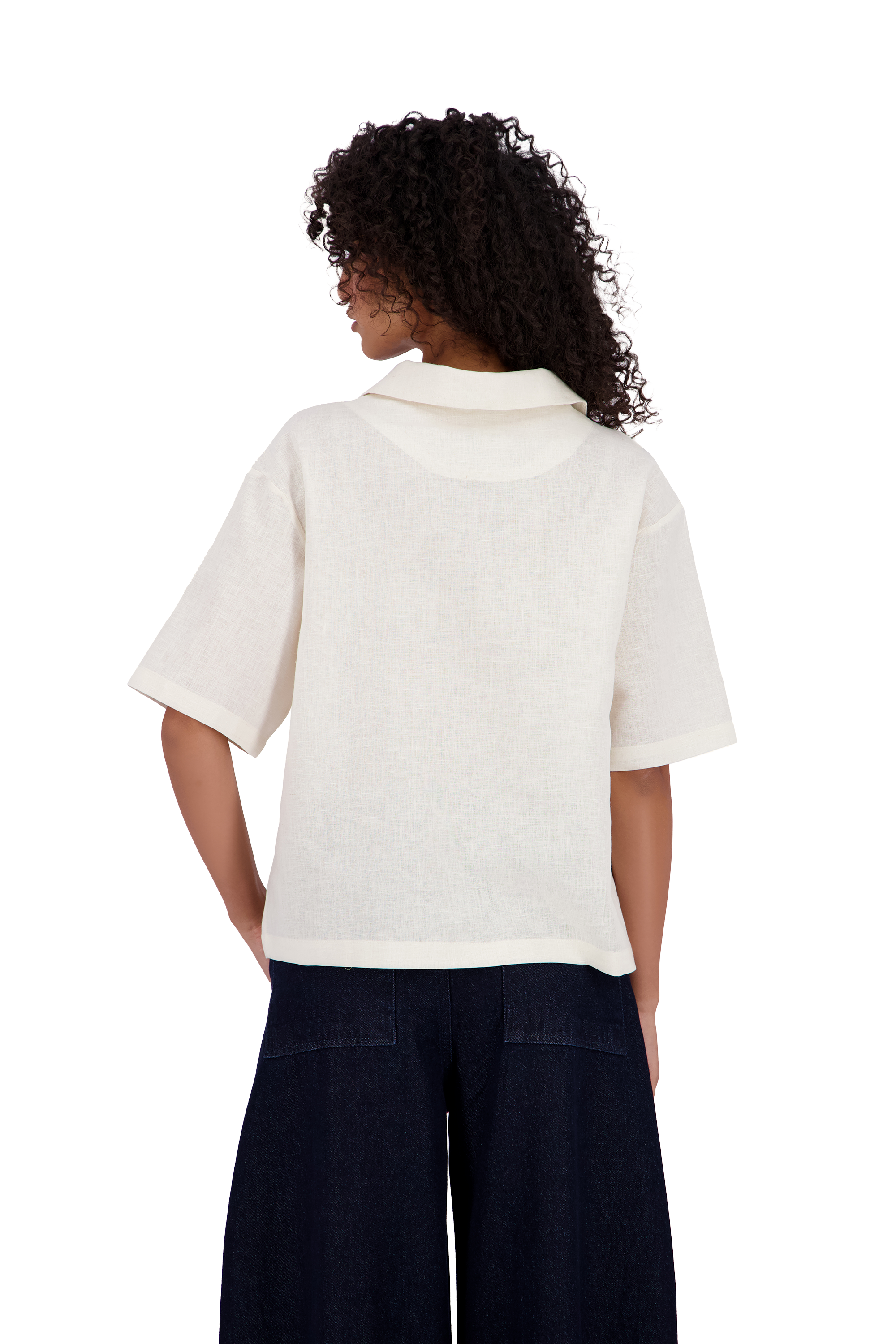 A woman viewed from the back wearing a short-sleeve cream-colored collared shirt and dark navy wide-leg pants, set against a plain white background. #Milk_Dune
