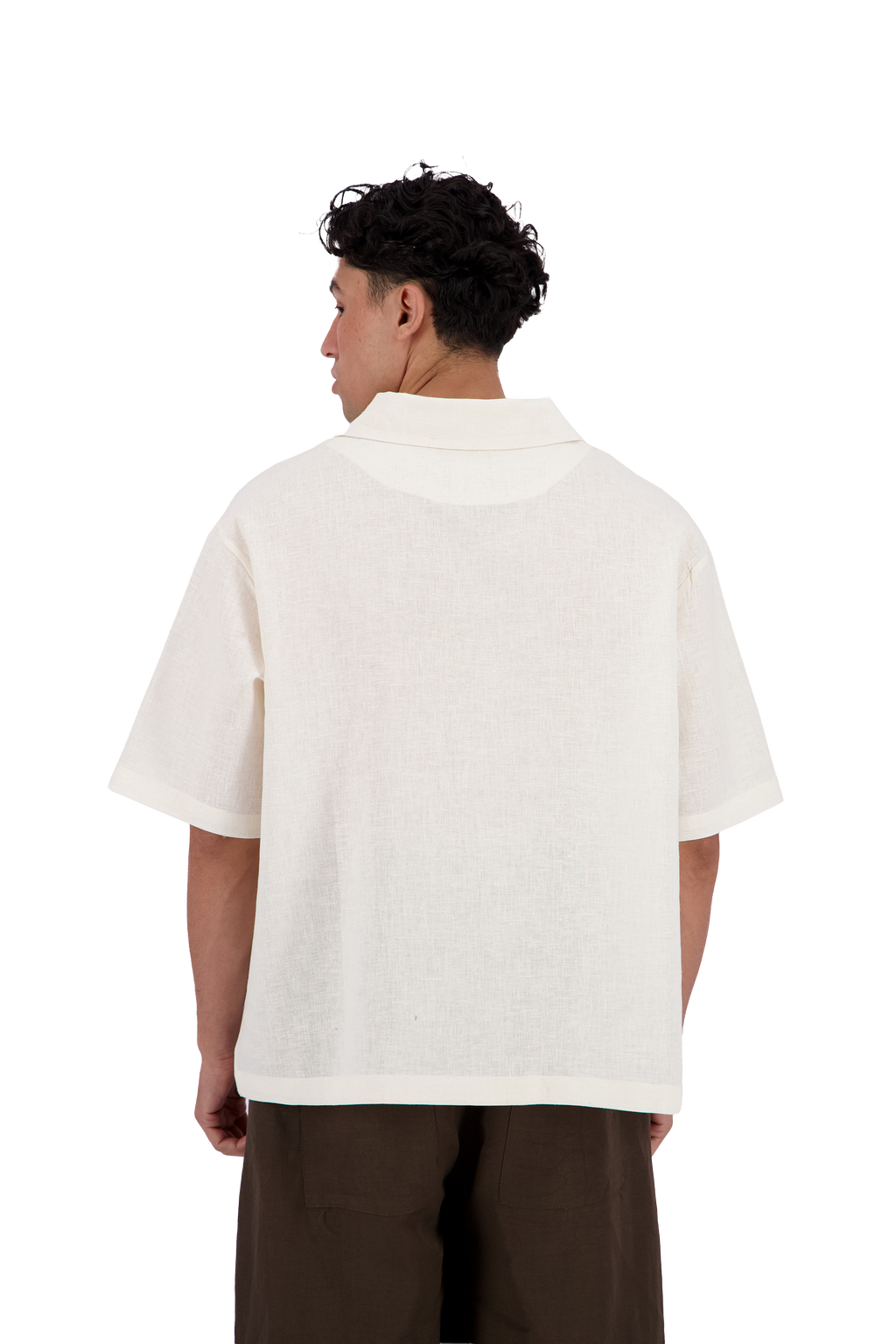 A man viewed from the back wearing a short-sleeve white knit polo shirt and dark brown pants, shot against a solid white background. #Milk_Dune
