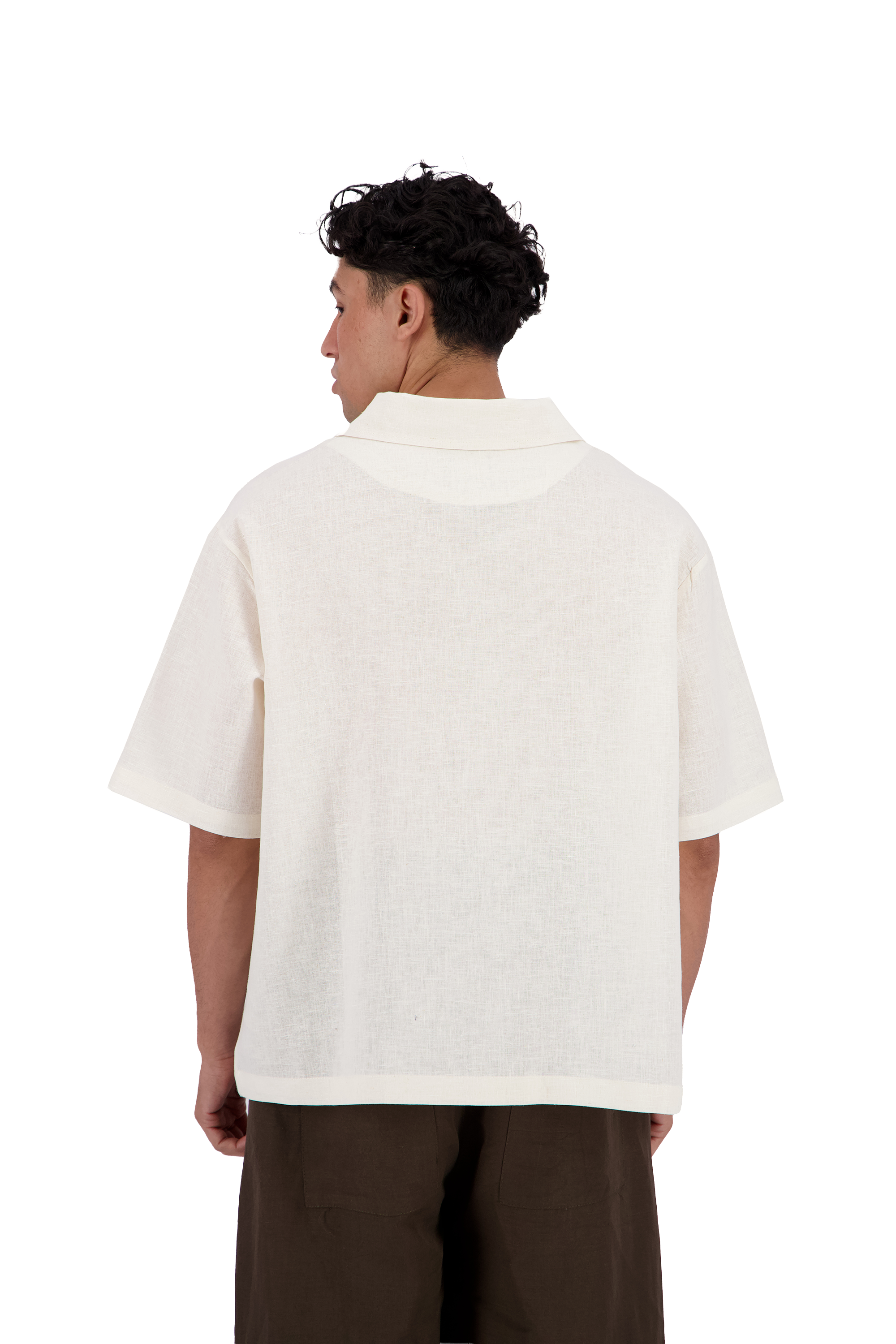 A man viewed from the back wearing a short-sleeve white knit polo shirt and dark brown pants, shot against a solid white background. #Milk_Dune