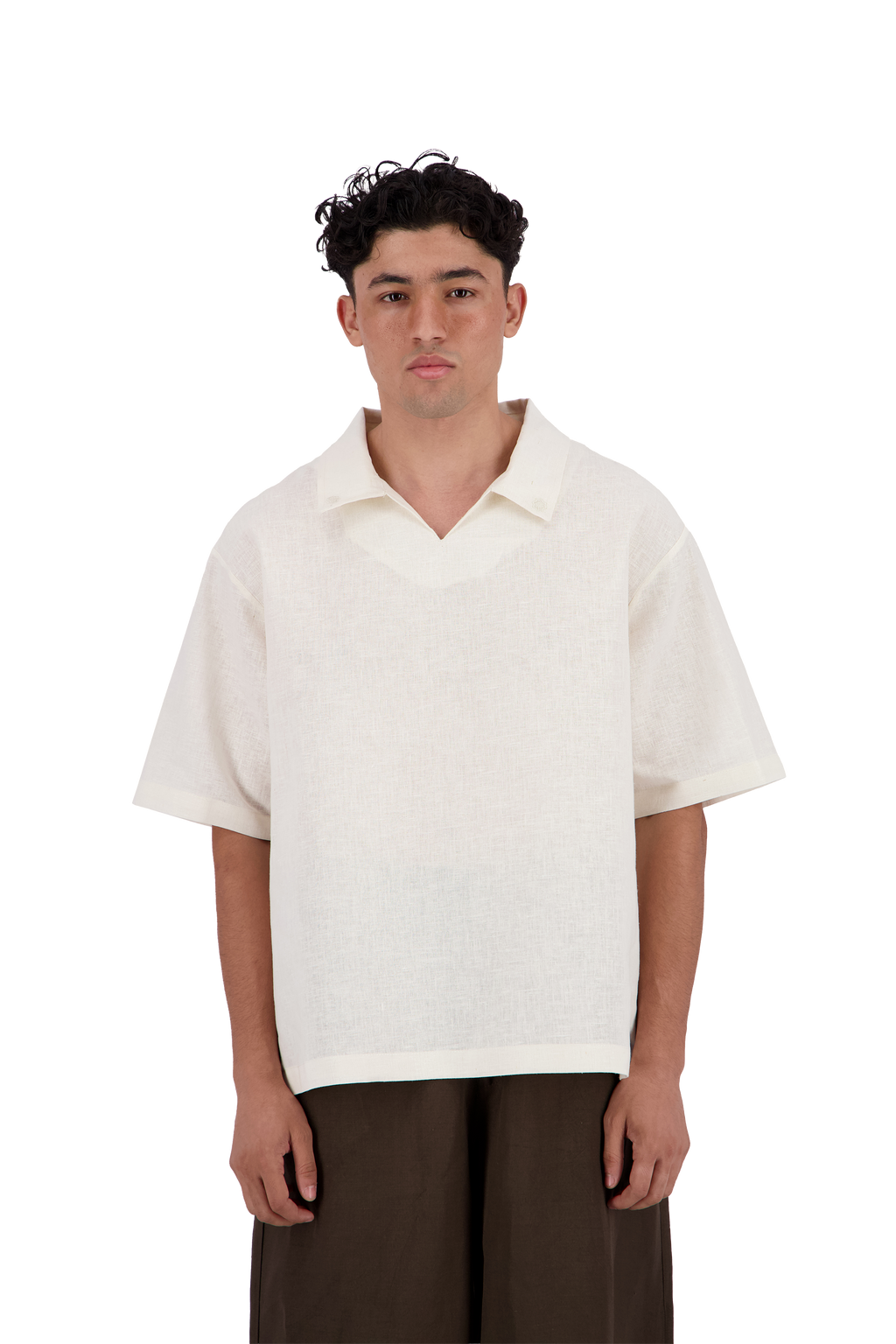 A man wearing a short-sleeve, v-neck knit polo shirt in off-white, paired with dark brown trousers, standing against a solid white background. #Milk_Dune